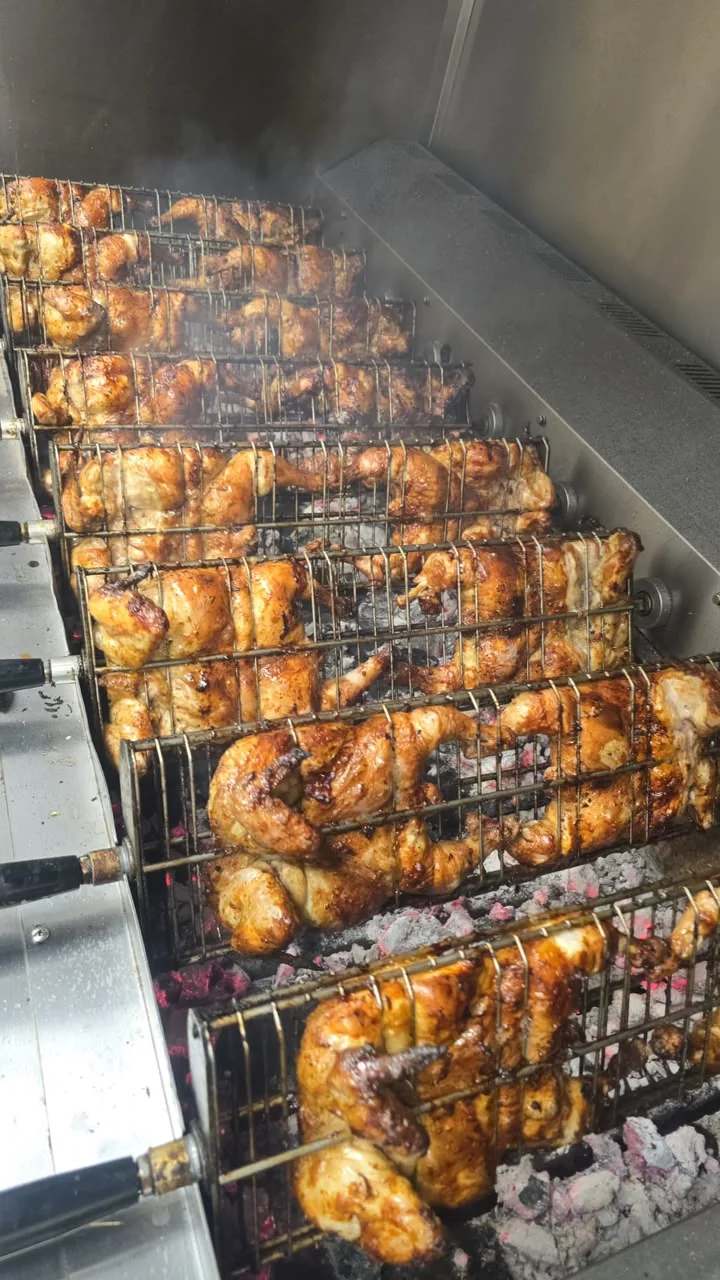 Pollos cocinándose sobre brasas de carbón